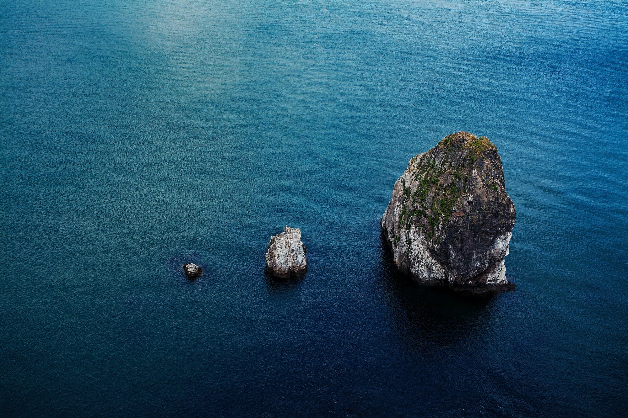 Ergonomics Risk Management Program shown with 3 rock cliffs in the ocean