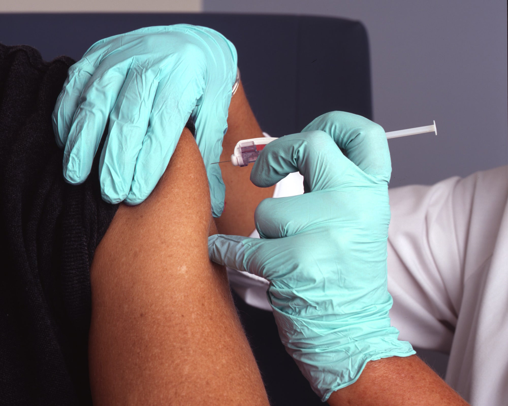 Occupational health flu vaccination injected into workplace employee